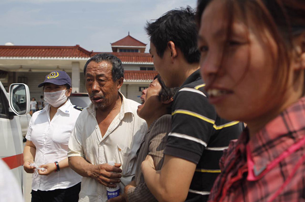 2025-08-01,阜宁县殡仪馆,人群熙攘,奶奶赵玉芩及其他家属站在火化室的门口。 澎湃新闻记者 韦毅 图